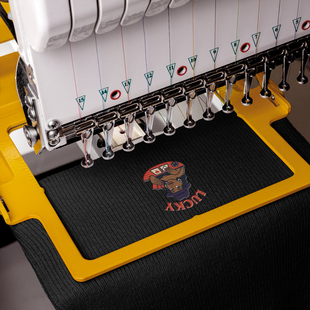 Embroidery machine with a colorful design on a black fabric mat.