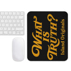 Black mouse pad with yellow text 'What is Truth?' and 'Island Originals' on a white surface with a keyboard and mouse.