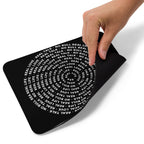 Black mouse pad with white text and a hand touching it