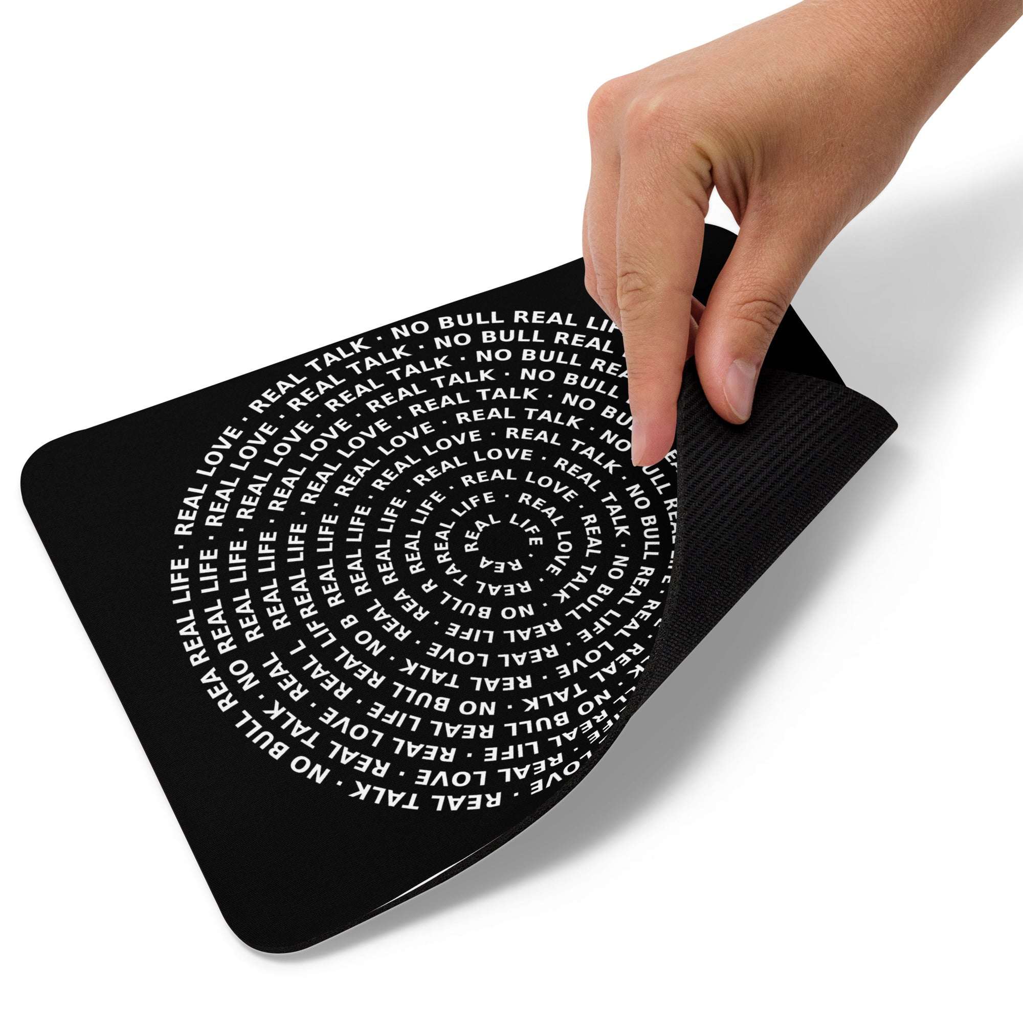 Black mouse pad with white text and a hand touching it