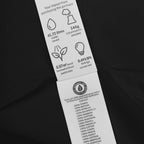 Clothing label with environmental impact details and organic certification on a black background